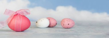 pembe ve beyaz yumurta, bir bulanık mavi gökyüzü bulutlu panoramik afiş biçimindeki karşı bir şerit ile alanı Kopyala