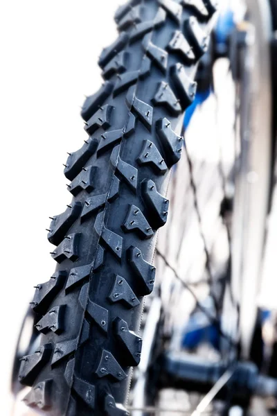 Neumático de una bicicleta de montaña sobre un fondo blanco, detalle de cerca, vertical —  Fotos de Stock