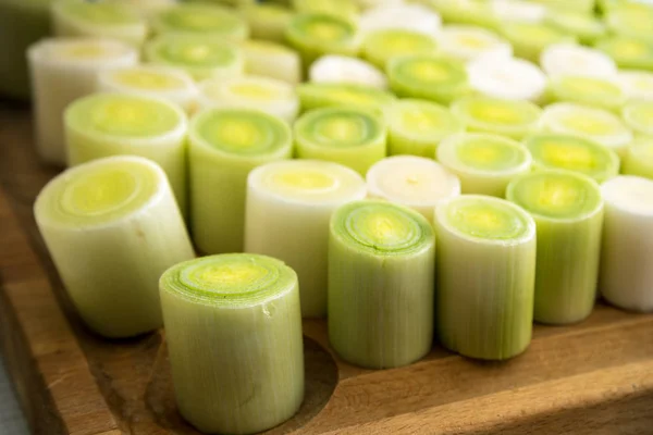 Fresh leek on a wooden board, organic vegetable slices prepared for cooking — Stock Photo, Image