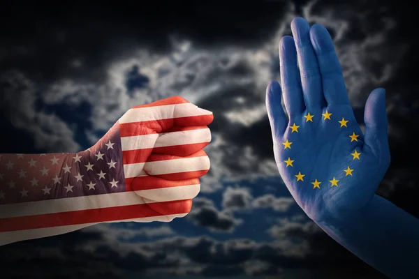 Conflito comercial, punho com bandeira dos EUA contra uma mão com bandeira europeia, céu nublado dramático no fundo — Fotografia de Stock