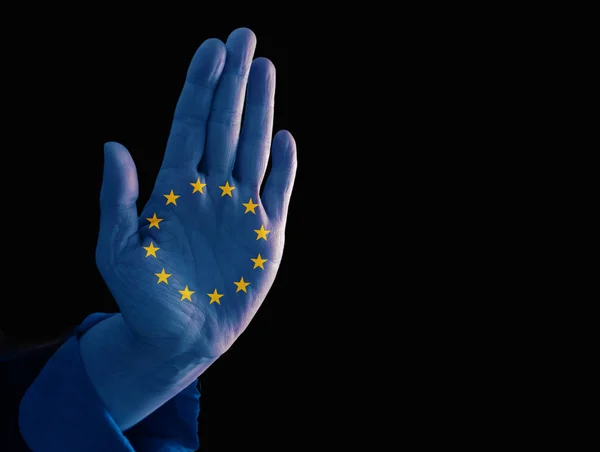 Hand met Europese vlag tonen stop gebaar om te voorkomen dat de immigratie van vluchtelingen, geïsoleerd op een zwarte achtergrond met kopie ruimte, politiek concept — Stockfoto