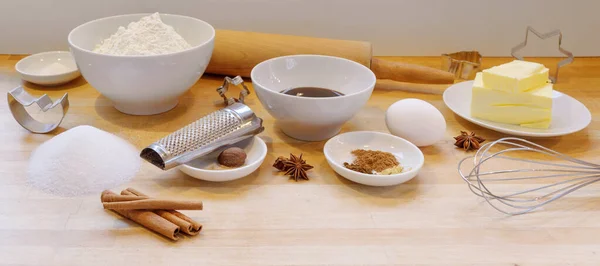 Cozimento biscoitos de gengibre para o Natal, ingredientes e utilitários em uma bancada de madeira leve na cozinha, formato panorâmico — Fotografia de Stock