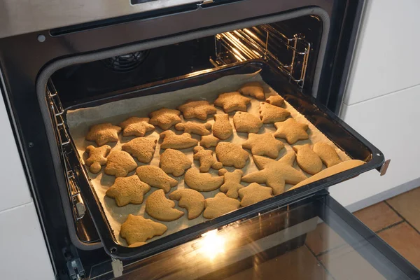 Kue jahe yang baru dipanggang di atas baking tray dalam oven untuk waktu Natal yang manis — Stok Foto