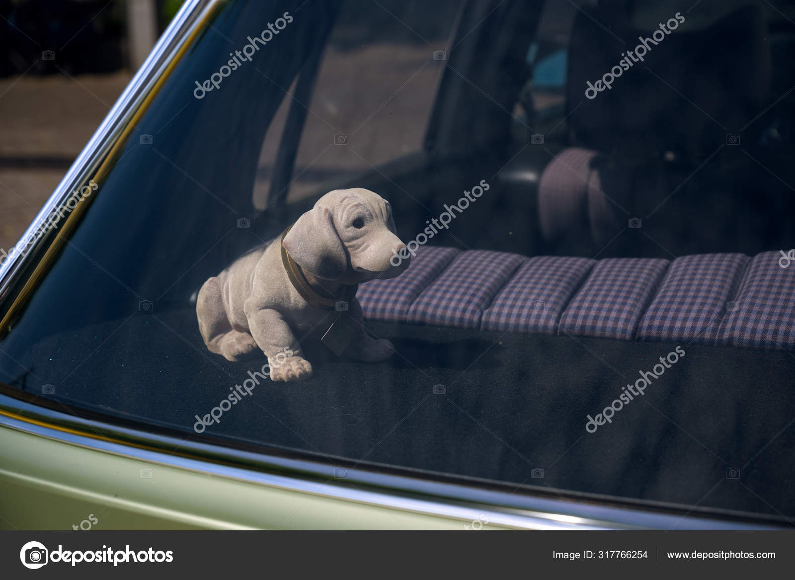 Bobblehead dachshund, in german wackeldackel, on the parcel shelf