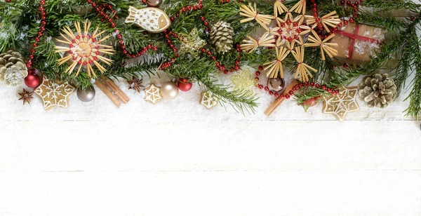 Weihnachtsbordüre mit Tannenzweigen, Strohsternen, Kugeln und Dekoration auf weiß lackiertem Holz im Panoramaformat, Kopierraum, hochwinkeliger Blick von oben — Stockfoto