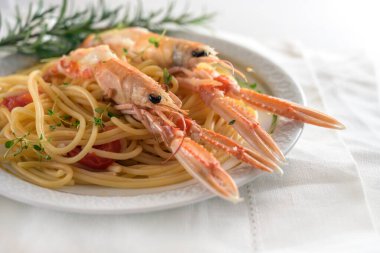 Langoustine, ayrıca karides ya da Norveç ıstakozu olarak da bilinir, domatesli, sarımsaklı, parmesan peynirli ve otlu bir spagetti menüsünde, Noel, Yeni Yıl ya da Paskalya gibi bayramlarda pahalı ama lezzetli deniz ürünleri yemeği.