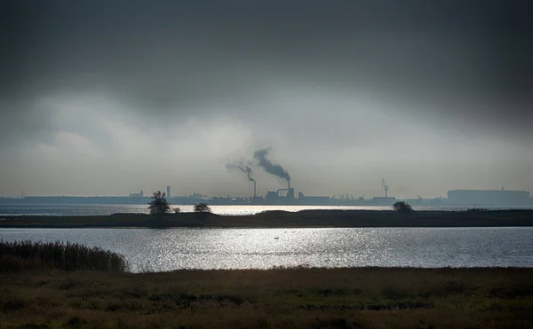 Utsikt från den tyska ön Poel över Östersjön till industrihamnen i Wismar på en dyster molnig dag, kopiera utrymme i den mörka himlen — Stockfoto