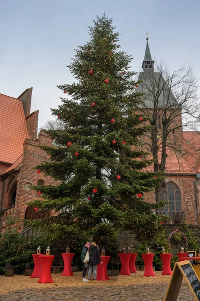 Moelln - 7. Dezember 2019: Große Tanne mit roten Kugeln und Lichterkette auf dem Weihnachtsmarkt an der Kirche in moelln, schleswig-holstein, Norddeutschland — Stockfoto