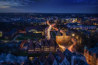 Holstentor ve tarihi Salzspeicher evleri ile aydınlık şehir Luebeck, Almanya 'nın hava gece görüşü, mavi saatte uzun süreli maruz kalma, kopyalama alanı