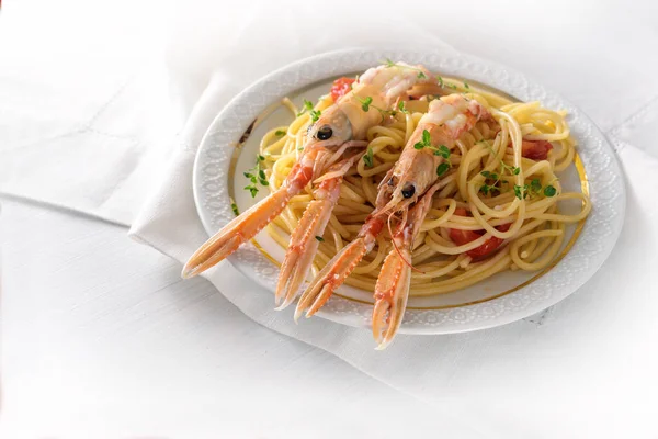 Langoustin, även kallad scampi eller norsk hummer, på en Medelhavet spaghetti måltid med tomater, vitlök, parmesanost och örter, dyra men läckra skaldjur måltid för en festlig semester som jul, nyår eller påsk — Stockfoto