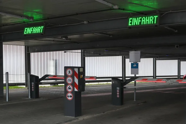 多階建ての駐車場または駐車場には、障壁と駐車券の自動販売機、ドイツ語のEinfahrtというラベルが付いています。 — ストック写真