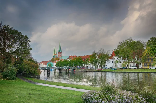 Paesaggio urbano del centro storico di Luebeck, Germania presso il fiume Trave, cielo drammatico con nuvole, copiare spazio — Foto Stock