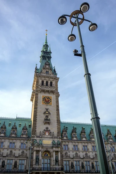 Clock tower of the historic town hall in the city of Hamburg against a blue sky with clouds — 图库照片