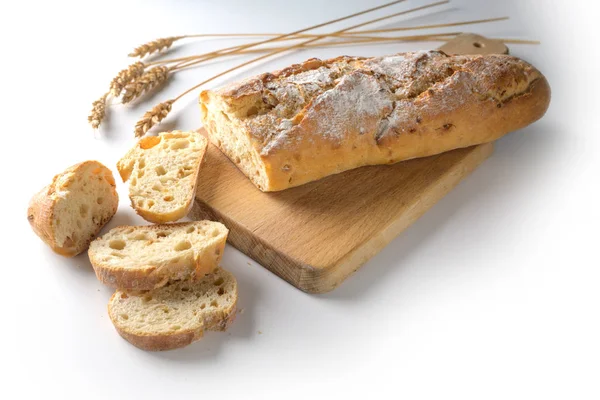 Baguette o pan francés al horno con cebolla en una tabla de cortar de madera sobre un fondo blanco, espacio para copiar —  Fotos de Stock