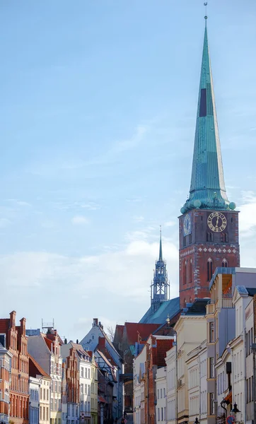 Torre della chiesa di San Jakobi sopra le case storiche nel centro storico di Luebeck in Germania, Europa, cielo blu con spazio copia — Foto Stock