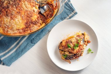 Camdan bir güveçte pişirilen musakka, geleneksel Yunan patlıcan, patates, kıyma ve domates tabağında servis ediliyor. Kopya alanı, yukarıdan yüksek açı, seçilmiş odak noktası.