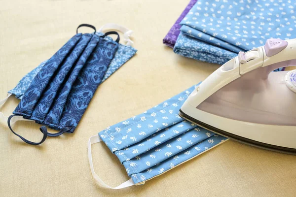 Ironing homemade cloth face mask, sewing against coronavirus infection during the lack of surgical masks, selected focus, narrow depth of field — Stock Image Ironing Homemade Cloth Face Mask Sewing Coronavirus Infection Lack Surgical Royalty Free Stock Photos
