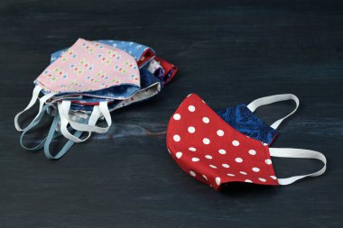 Koyu mavi ahşap üzerinde Coronavirus salgınına karşı korunmak için desenli pamuktan dikilmiş ev yapımı yüz maskeleri, kopyalama alanı, seçilmiş odak, dar alan derinliği