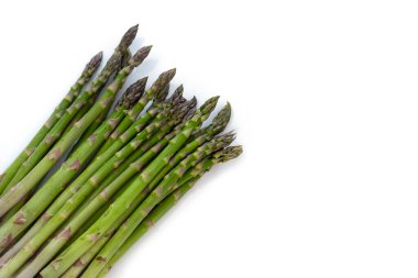 Köşede, beyaz arkaplanda küçük gölgeler, kopyalama alanı, yukarıdan yüksek açı görüntüsü ile izole edilmiş organik yeşil kuşkonmaz (asparagus officinalis) demeti.