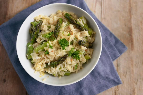 Risotto Zöld Spárgával Parmezánnal Petrezselyemmel Díszítve Fehér Tálban Szalvétára Rusztikus — Stock Fotó