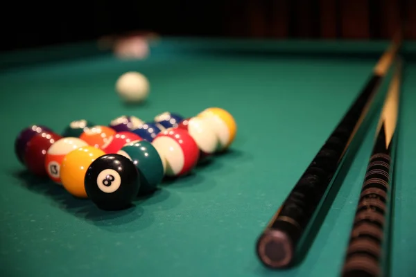 緑の布にビリヤードのスポーツゲーム 2つのキュー キューボールとプールテーブル上の三角形の形で多色のビリヤードボール ビリヤードボールが閉じます ストック画像