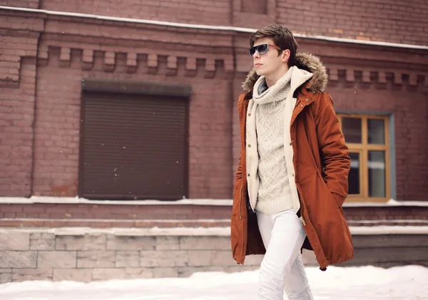 Модный стильный мужчина в куртке и солнцезащитных очках, идущий в c — стоковое фото