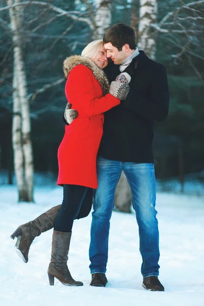 Счастливая молодая пара влюблённая обнимается в зимний холодный день — стоковое фото