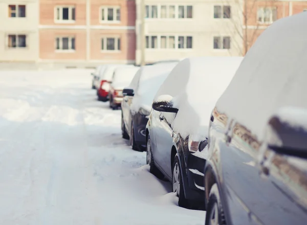 Samochody pokryte śniegiem na stree w zimowy dzień — Zdjęcie stockowe