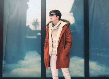 Moda kentin kentsel cam üzerine bir ceket giyen genç adam 