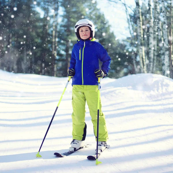 Professionele skiër kind jongen in sportkleding en helm, zonnige win — Stockfoto
