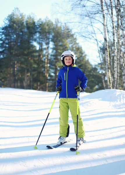 Sciatore professionista bambino ragazzo in abbigliamento sportivo casco su sci inverno , — Foto Stock