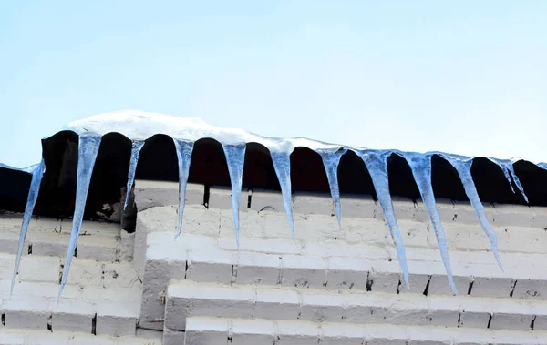 Sezon, konut ve kış konsepti - cephe r üzerinde asılı buz sarkıtları — Stok fotoğraf