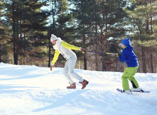 Winter glücklich junge lächelnde Mutter mit Söhnchen gehen Skifahren — Stockfoto