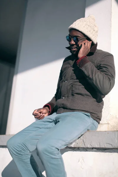 Moda joven africano hombre hablando en el teléfono inteligente en la ciudad —  Fotos de Stock