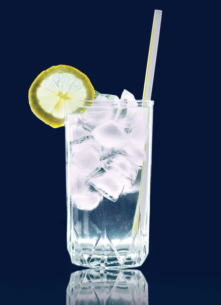 Refreshing cocktail glass with ice cubes and lemon slice straw t — Stock Photo, Image