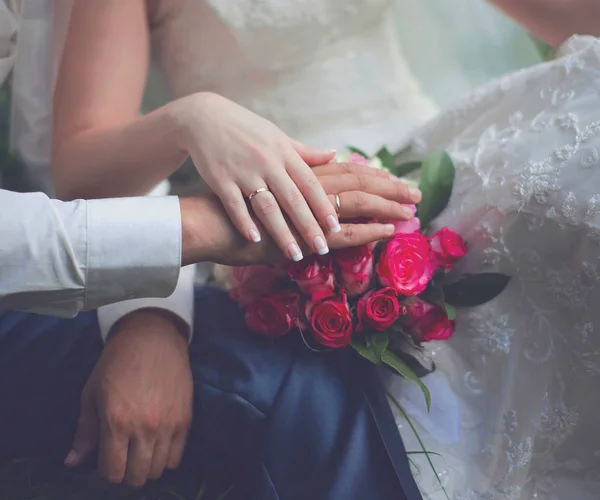 Свадебная пара, жених и невеста, руки с кольцами и розовый благородный — стоковое фото
