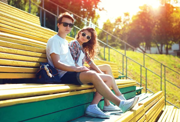 Moda joven pareja adolescentes descansando en la ciudad en el banco en s — Foto de Stock