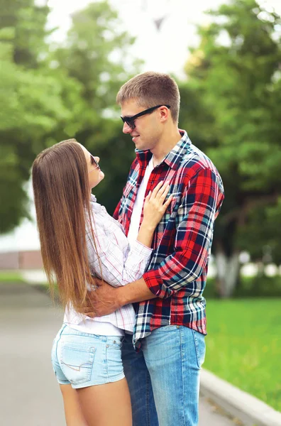 Счастливая молодая пара на открытом воздухе обнимается в летнем парке — стоковое фото