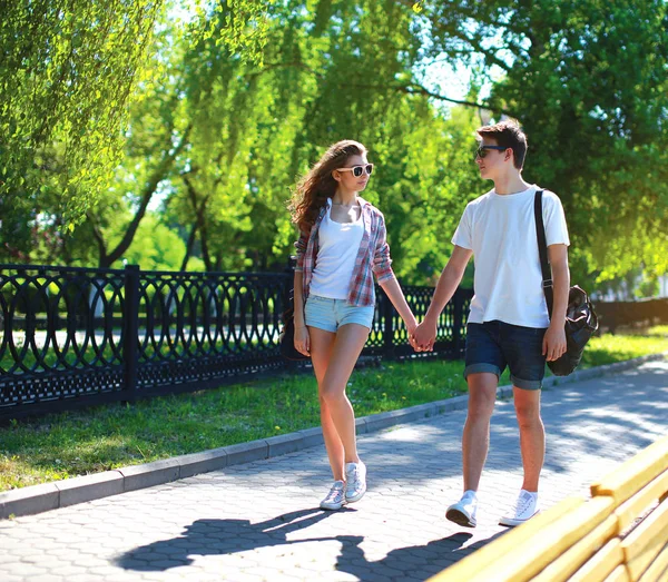 Счастливая молодая пара, гуляющая в летнем парке — стоковое фото