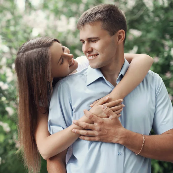 Portrét šťastná mladá usmívající se pár v lásce přes kvetoucí Ružina — Stock fotografie