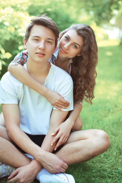 Retrato dulce sonriente joven pareja adolescentes sentado en el gra — Foto de Stock