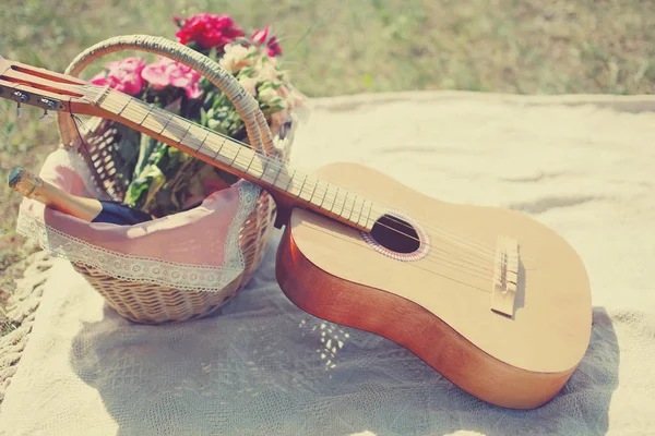 Guitarra de foto romântica, cesta com vinho, flores de buquê em plai — Fotografia de Stock