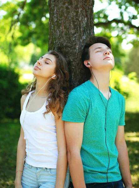 Jovem casal em fones de ouvido desfrutando ouve música na cidade — Fotografia de Stock