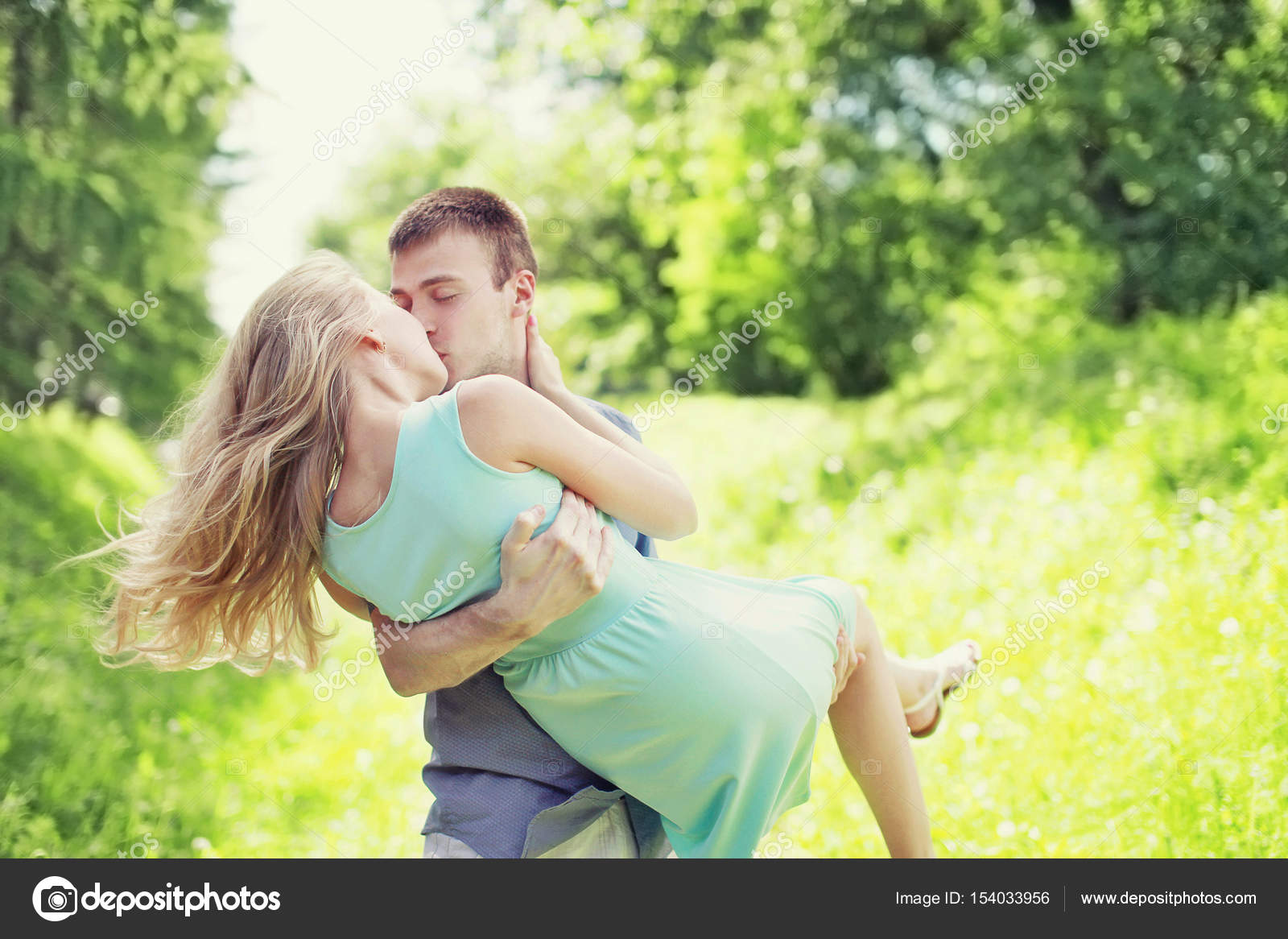 Happy young sweet couple is kissing, man and woman in love, he h ...