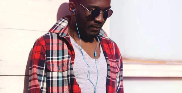 Retrato de moda jovem homem africano escuta música em fone de ouvido — Fotografia de Stock