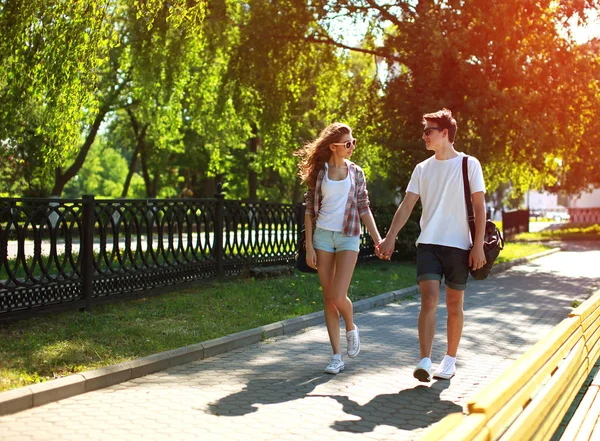 Счастливая молодая пара вместе гуляющая по летнему парку — стоковое фото