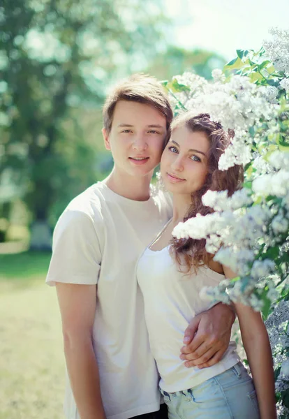 Весенний портрет молодой пары подростков в цветущем саду — стоковое фото