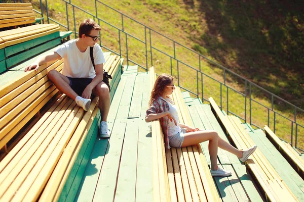 Молодая пара отдыхает на скамейке, молодежь, подростки, мода - кон — стоковое фото