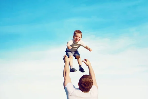 Happy father throws son child into the air, carefree having fun — Stock Photo, Image