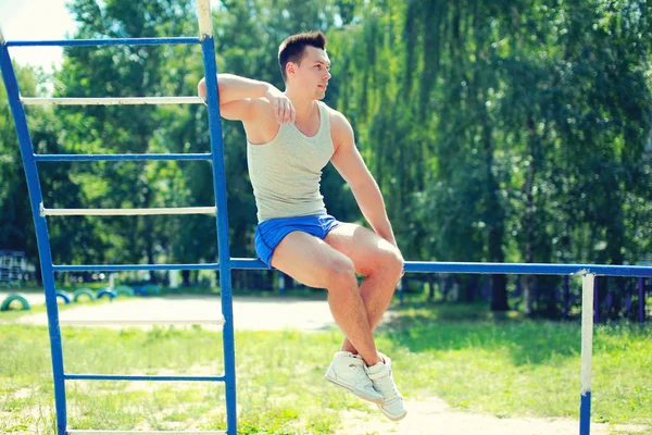 Sport, street workout concept - sportsman sitting on the horizon — Stock Photo, Image